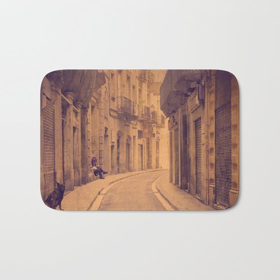 The dog in the narrow street of Barcelona Bath Mat