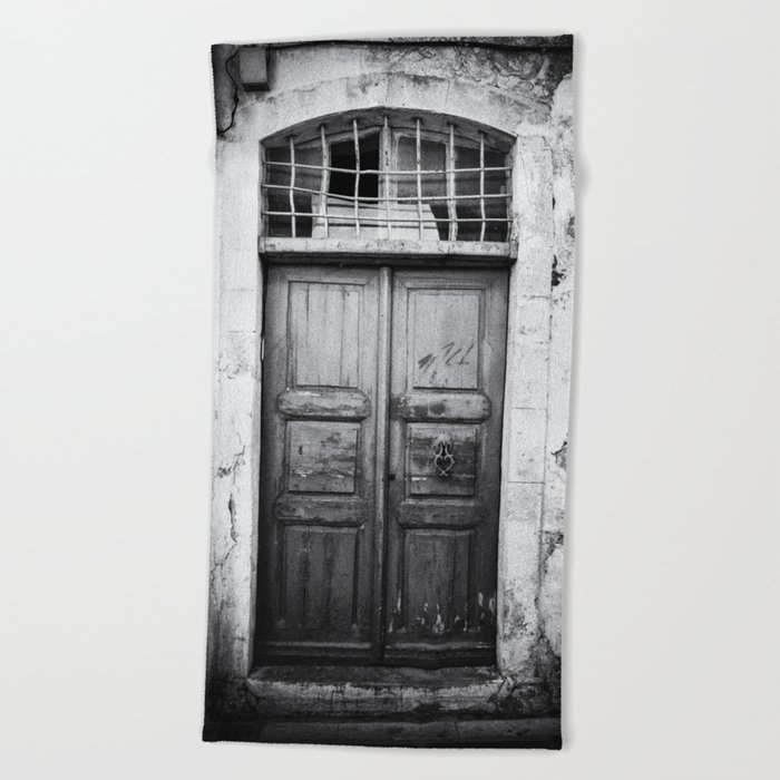 Old wooden door on the island of Crete, Greece in Black and White Beach Towel