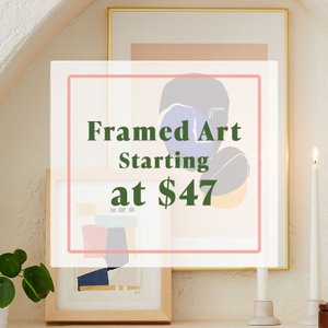 Two framed art prints displayed on a ledge against wall