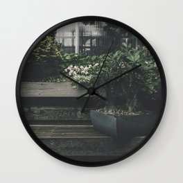 Potted plant on a wooden plank in the garden Wall Clock