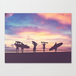 Silhouette Of surfer people carrying their surfboard on sunset beach, vintage filter effect with soft style Canvas Print