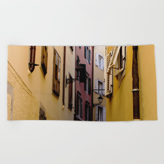 Narrow color street full of vibrant color houses in Italy Beach Towel