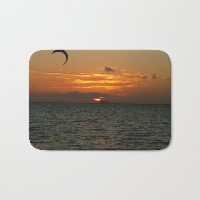 Sunset in the calm sea with red sky, gray cloud and a parachute Bath Mat