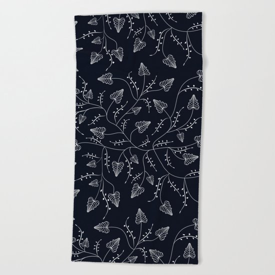 Delicate leaves on a black background . Beach Towel