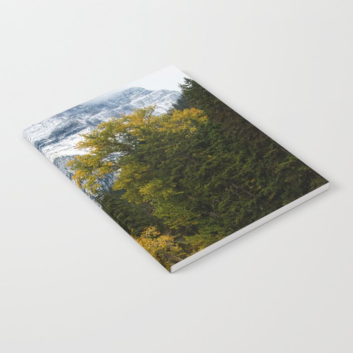 Transitions - Snowy Mountain Peak Overlooking Trees with Fall Color on Autumn Day in Glacier National Park Montana Notebook