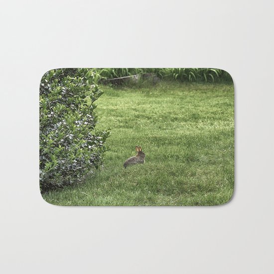 Baby rabbit enjoying sunshine Bath Mat