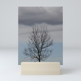 Bald tree carrying a dark cloud Mini Art Print
