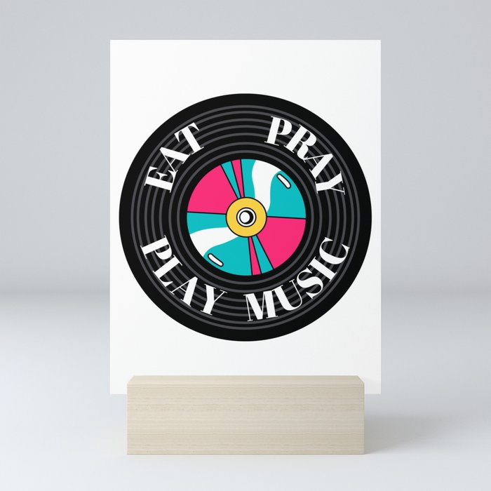 The circular colored illustration shows a black vinyl on which the words eat, pray, play music Mini Art Print