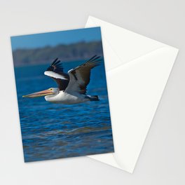 A pelican flying low over the water - portrait Stationery Cards