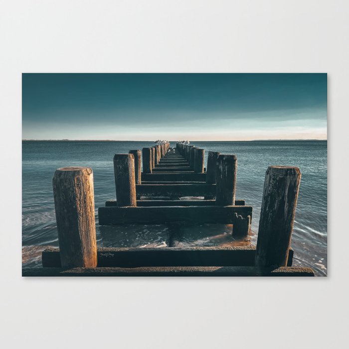 Wooden piers and seagulls on a peaceful morning with calm ocean Canvas Print