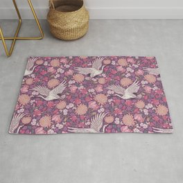 Cranes with chrysanthemums and pink magnolia on purple background Rug