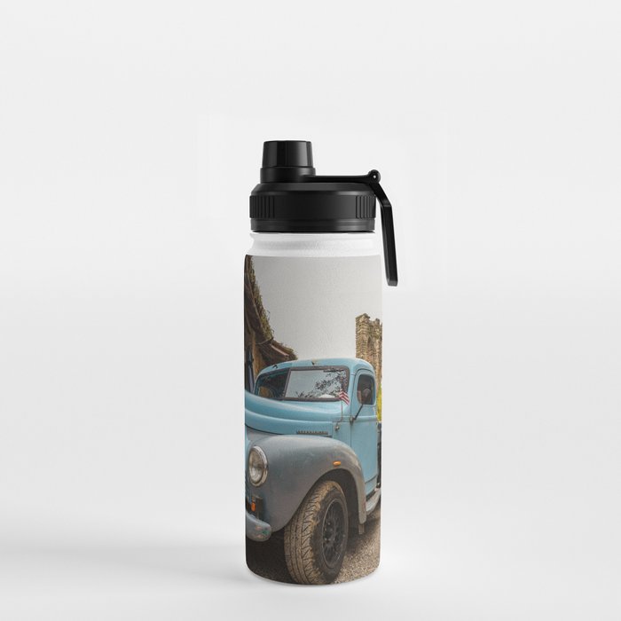 Historic blue-colored pickup parked in the streets of an historic Italian village Water Bottle