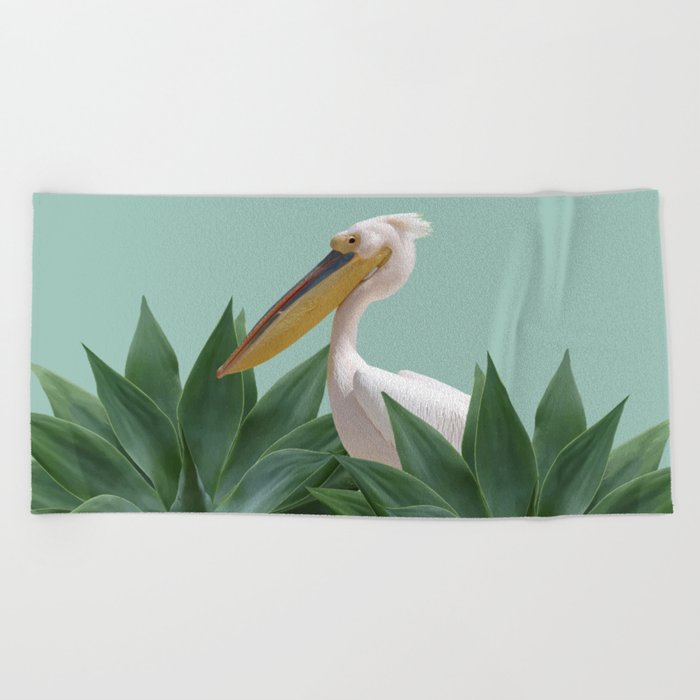 Pelican between agave leaves Beach Towel