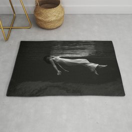 Underwater view of a woman floating in water Rug