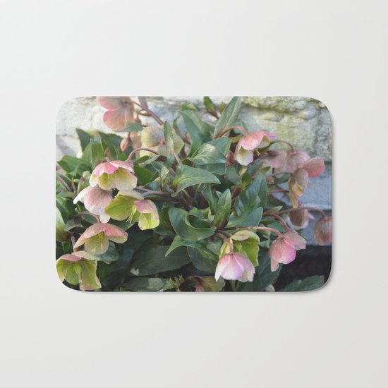 Pink flowers against an old brick wall Bath Mat