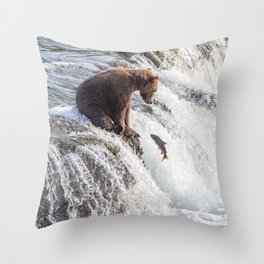 Young grizzly bear sits at waterfall Throw Pillow