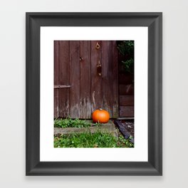 Orange pumpkin by wooden door Framed Art Print