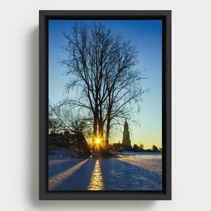 Sunrise on a frozen lake with a little church in the background Framed Canvas