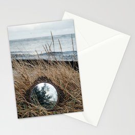 Vintage mirror on seaside reflects forest and sky. Stationery Cards