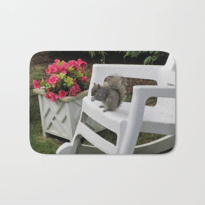 Cute Squirrel Enjoying a Snack on a Rocking Chair in the Garden Bath Mat