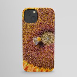 Close up view of a Sunflower bloom with a bee collecting pollen iPhone Case