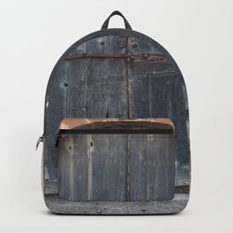 Old abandoned door with a weathered wall Backpack