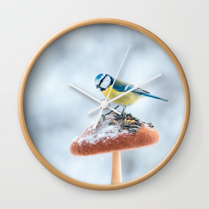 Blue tit feeding on the handmade feeder in winter snow forest. Wall Clock