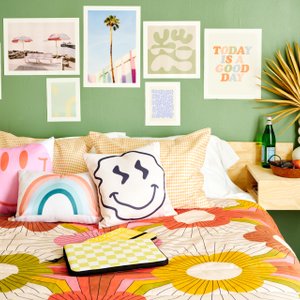 bed with colorful bedding and gallery wall above it