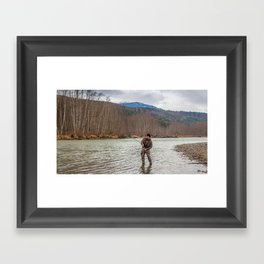 A fly fisherman hooked into a big fish in a the Kalum River, British Columbia, Canada, with the rod bent and aspen woodland on the far bank, and mountains in the background Framed Art Print