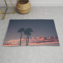 Silhouette of palm trees at sunset Rug