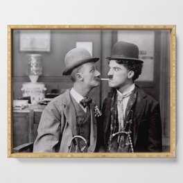 The tramp reluctantly shares a cigarette; vintage Charlie Chaplin funny Hollywood movie portrait black and white photograph - photography - photographs Serving Tray