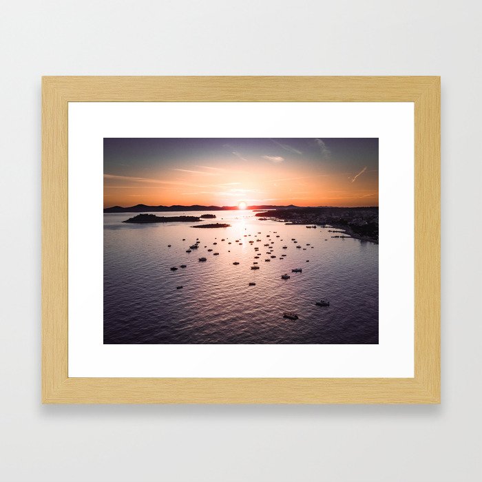 Dramatic sunset on the sea coast with boats in the sea Framed Art Print