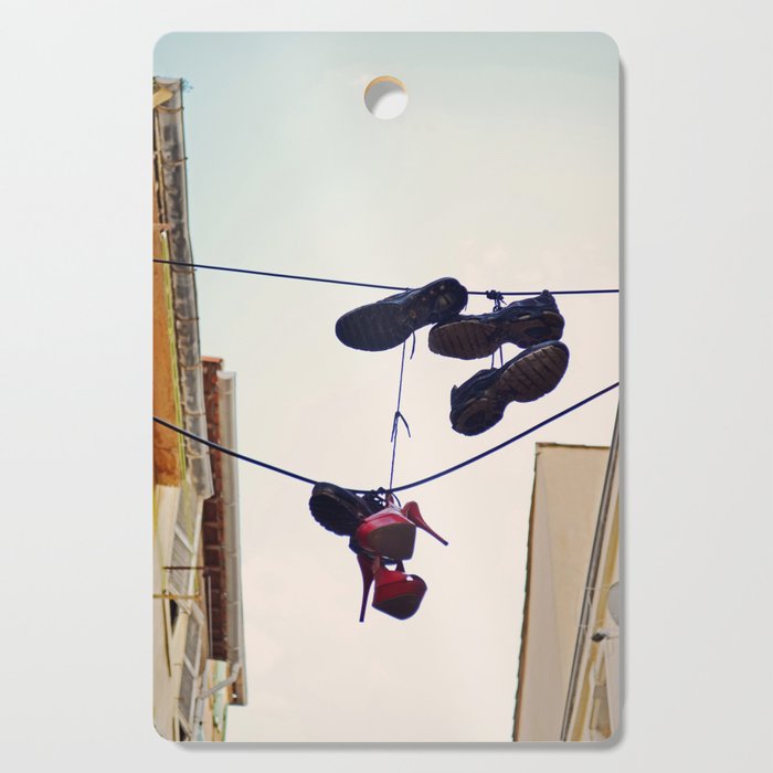 Red heels hanging from telephone wire in a street of Marseille, France | Shoe tossing Cutting Board