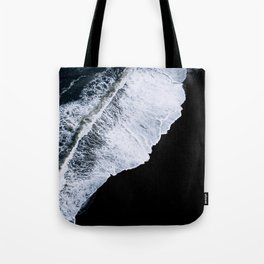 Waves crashing on a black sand beach Tote Bag