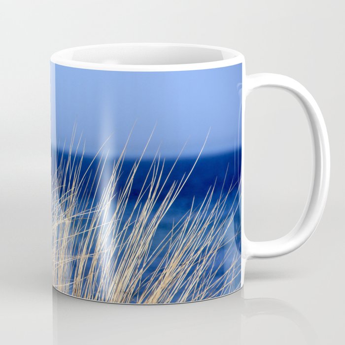 Dried long grass with blue sea behind and blue sky Coffee Mug