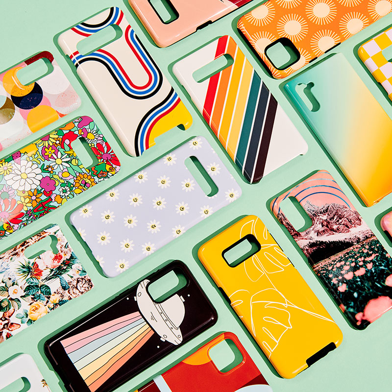flatlay with colorful phone cases on a green background