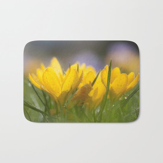 Yellow wet crocus at backlight Bath Mat