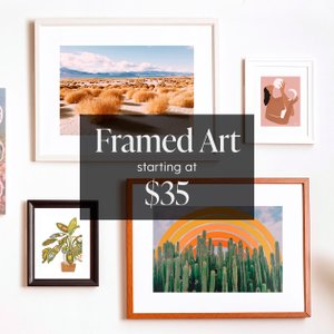 Assorted framed wall art hung on wall gallery style